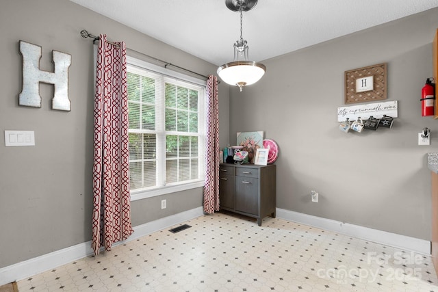 dining area with baseboards, visible vents, and light floors