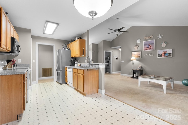 kitchen with appliances with stainless steel finishes, a sink, a ceiling fan, open floor plan, and visible vents