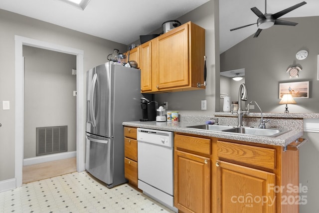 kitchen with white dishwasher, ceiling fan, a sink, light floors, and visible vents