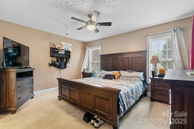 bedroom with baseboards, a ceiling fan, a textured ceiling, and light colored carpet