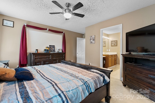 bedroom featuring light colored carpet, a ceiling fan, a textured ceiling, and ensuite bath