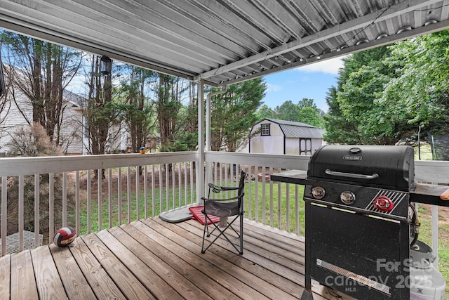 wooden deck featuring a lawn and a grill