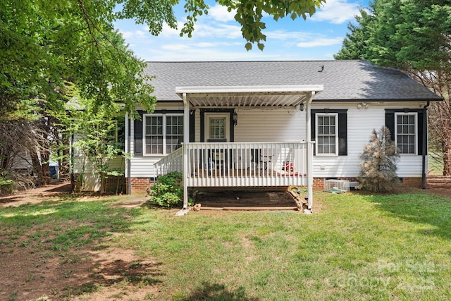 back of property with a lawn, crawl space, and a shingled roof