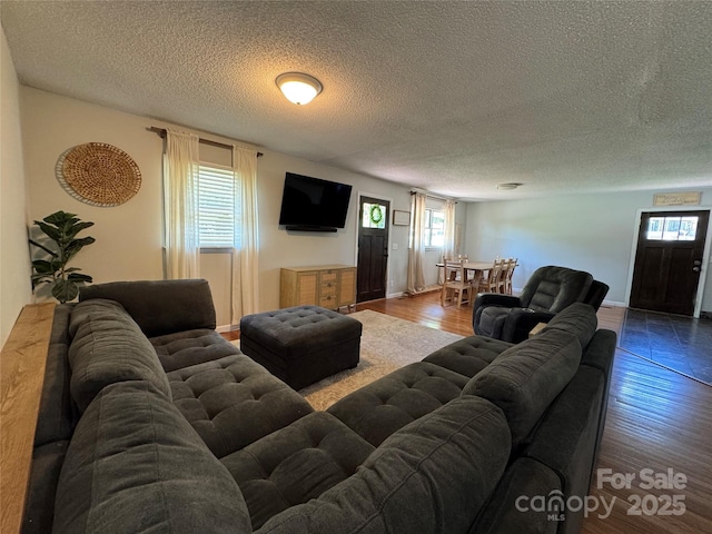 living area with a textured ceiling and wood finished floors