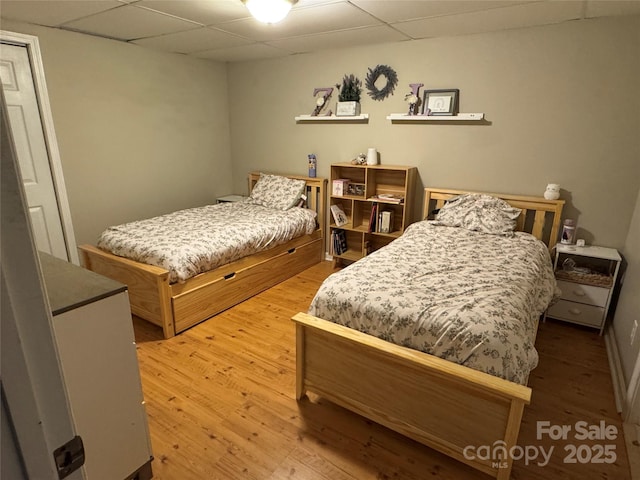 bedroom featuring a paneled ceiling and wood finished floors