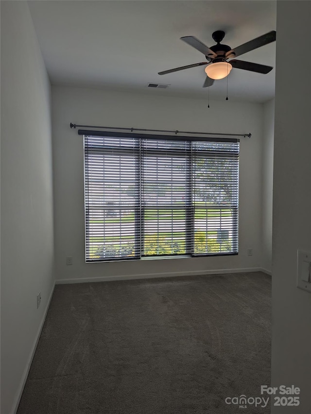unfurnished room featuring carpet floors, visible vents, and a wealth of natural light