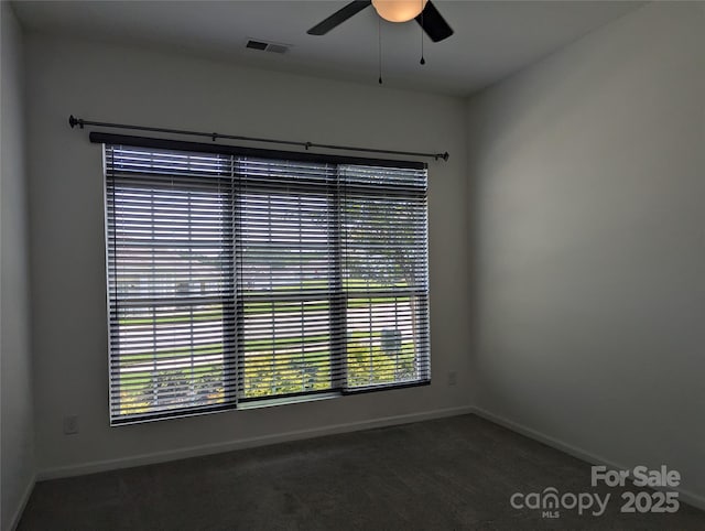 spare room featuring visible vents, carpet, baseboards, and ceiling fan