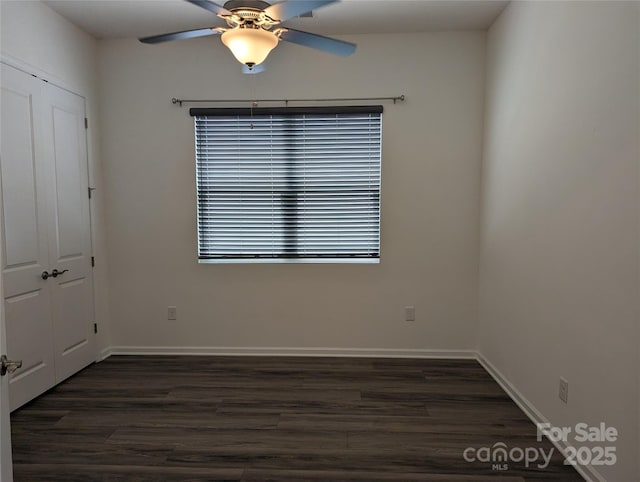 spare room with baseboards, ceiling fan, and wood finished floors