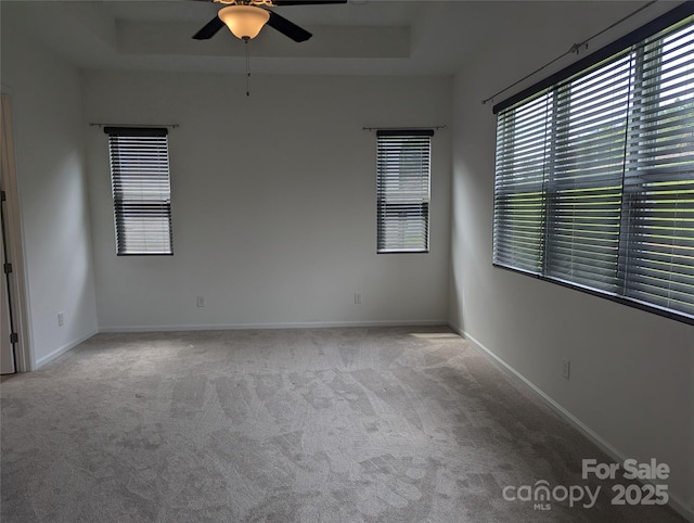 unfurnished room featuring plenty of natural light, carpet, and a ceiling fan