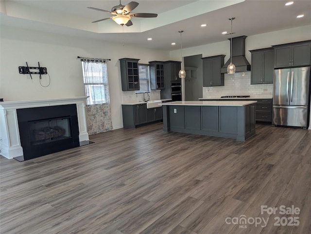 kitchen featuring freestanding refrigerator, premium range hood, recessed lighting, light countertops, and a ceiling fan