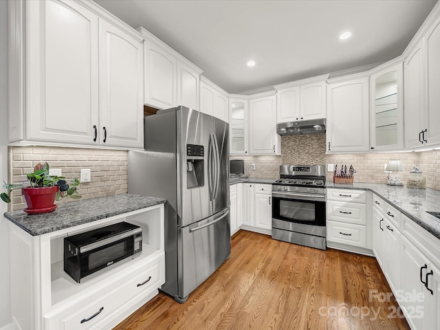 3133 English Sparrow Ln, Charlotte, NC 28210 - kitchen featuring under cabinet range hood, tasteful backsplash, glass insert cabinets, and appliances with stainless steel finishes