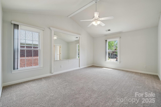 carpeted empty room with visible vents, lofted ceiling with beams, baseboards, and ceiling fan