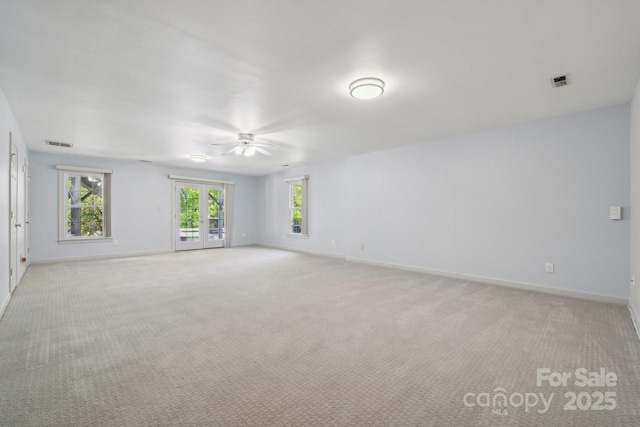 empty room with a ceiling fan, baseboards, visible vents, and plenty of natural light