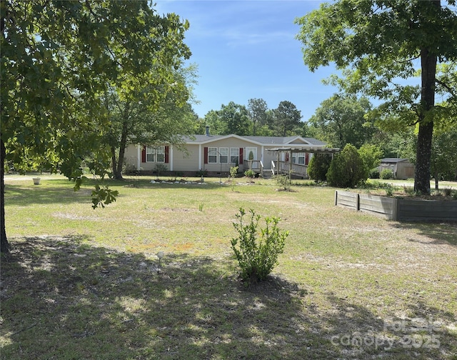 manufactured / mobile home with a vegetable garden and a front lawn