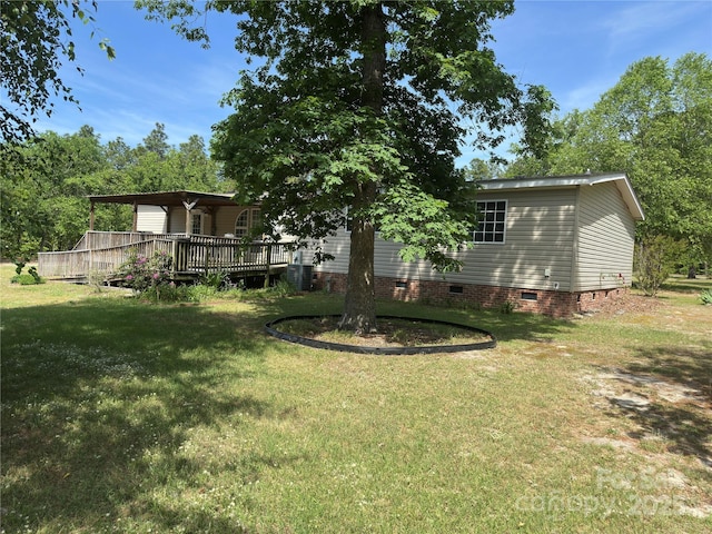 view of yard with central AC and a deck