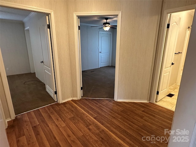 corridor with baseboards and wood finished floors