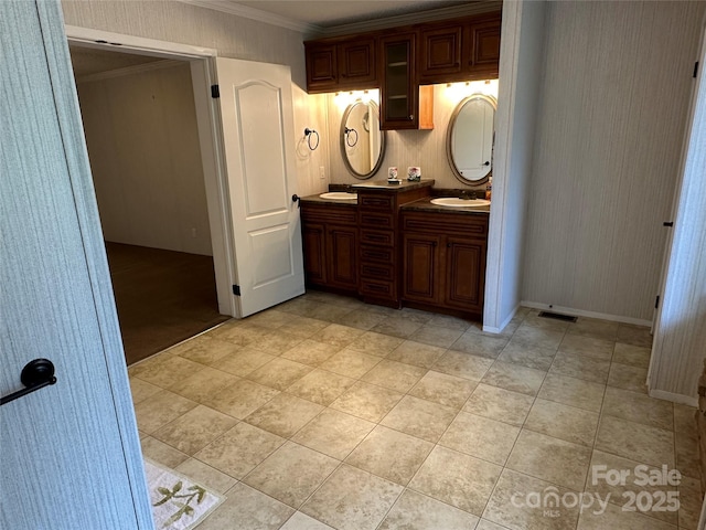 full bath with double vanity, baseboards, ornamental molding, and a sink