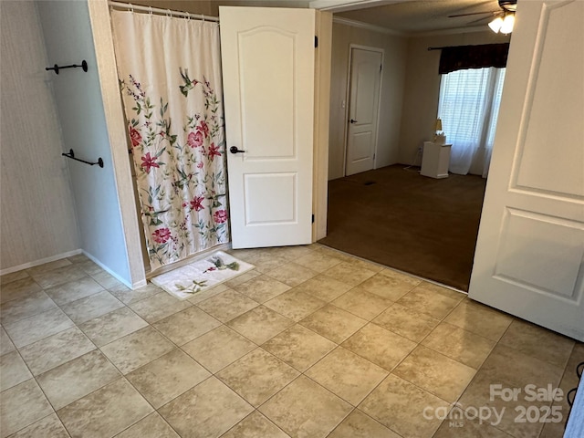 interior space with baseboards, ornamental molding, and light tile patterned floors