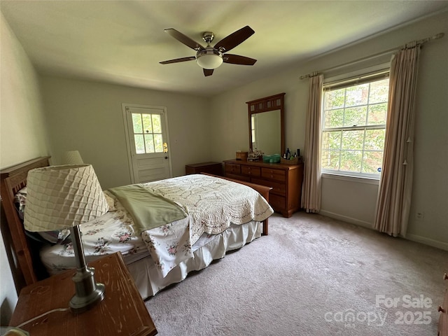 bedroom with light colored carpet, a ceiling fan, and baseboards