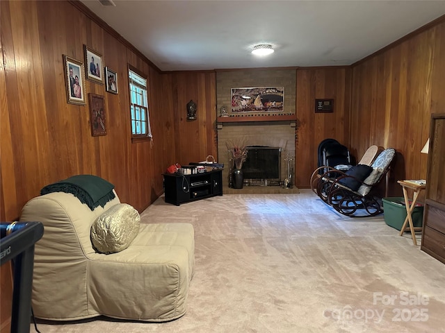 living area featuring light colored carpet, wood walls, a brick fireplace, and crown molding