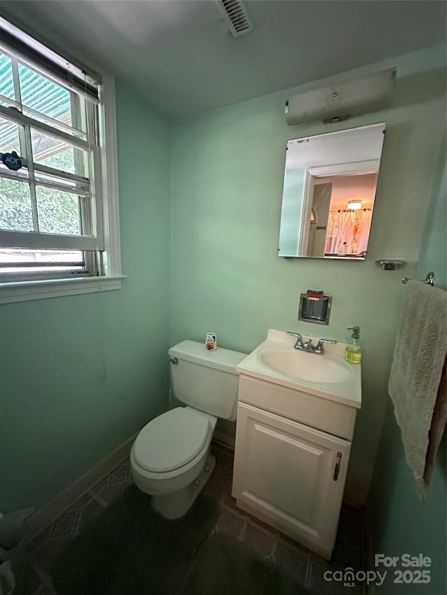 bathroom featuring toilet, visible vents, tile patterned flooring, and vanity