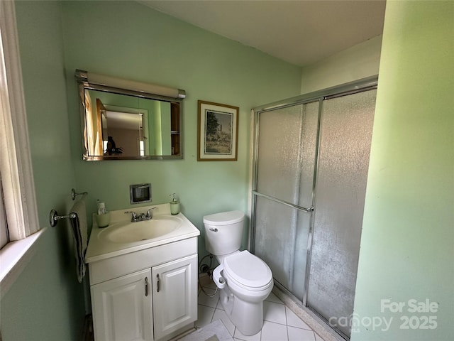 bathroom with vanity, toilet, tile patterned floors, and a stall shower