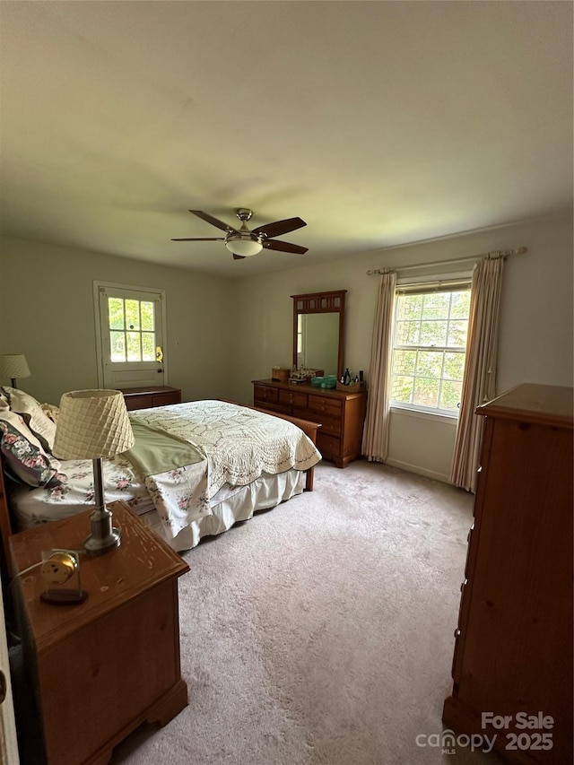 carpeted bedroom featuring ceiling fan and multiple windows