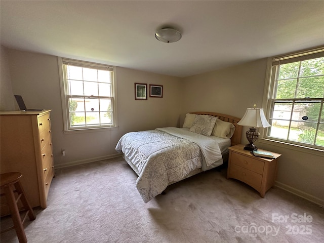 bedroom featuring baseboards and light carpet