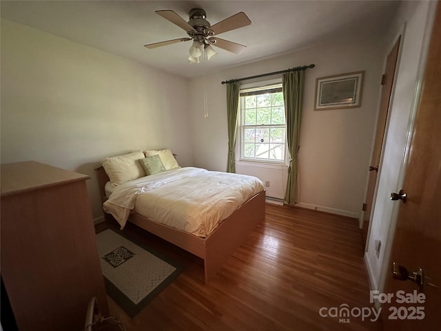 bedroom with baseboards, ceiling fan, and wood finished floors