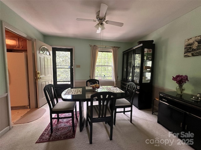 dining area with light colored carpet and ceiling fan