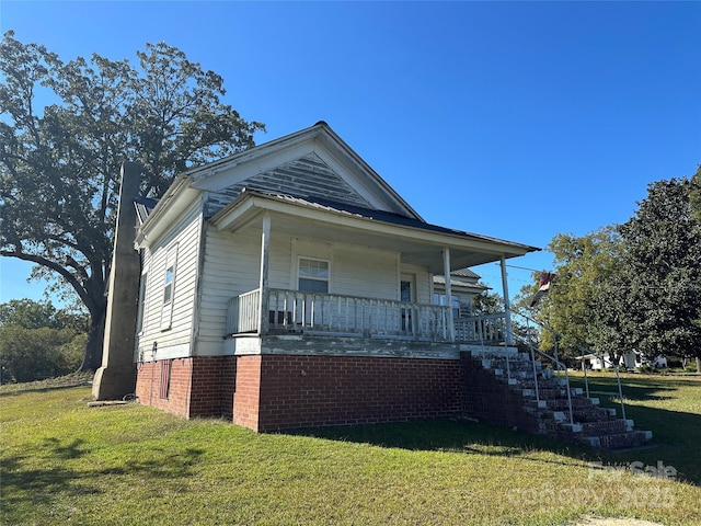 view of front of house with stairs, a porch, and a front yard