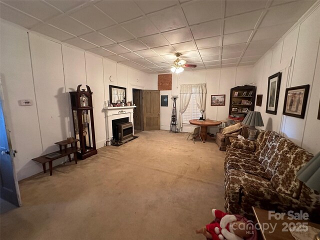 living room with light colored carpet, ceiling fan, and a drop ceiling