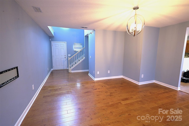 6614 Wicked Oak Ln, Charlotte, NC 28216 - spare room featuring wood-type flooring, a chandelier, and stairs