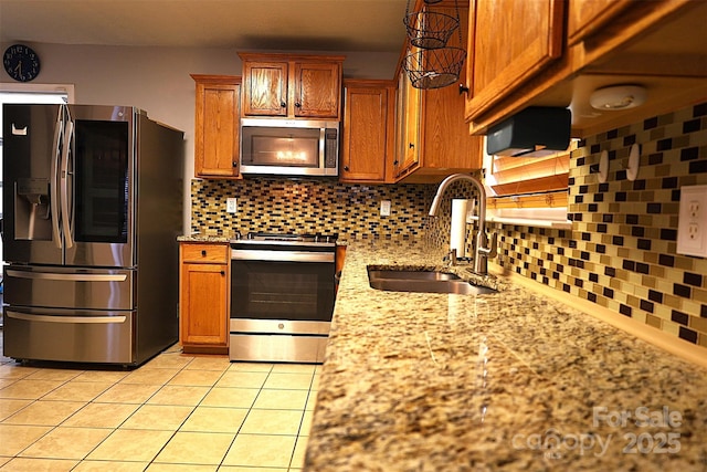 6614 Wicked Oak Ln, Charlotte, NC 28216 - kitchen with appliances with stainless steel finishes, brown cabinets, tasteful backsplash, light tile patterned floors, and light stone counters