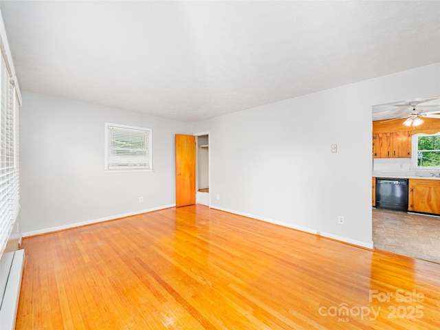 92 Church St, Weaverville, NC 28787 - unfurnished living room with light wood finished floors, baseboards, a baseboard heating unit, and a ceiling fan
