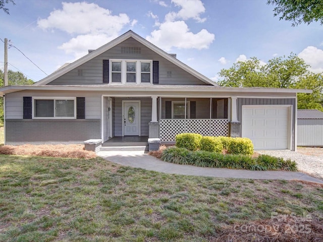 view of front facade featuring an attached garage, a front lawn, a porch, brick siding, and driveway