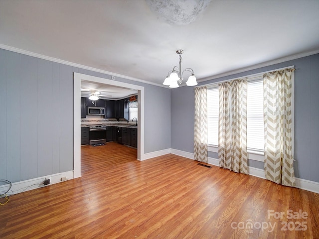 unfurnished dining area featuring a sink, a notable chandelier, plenty of natural light, and visible vents