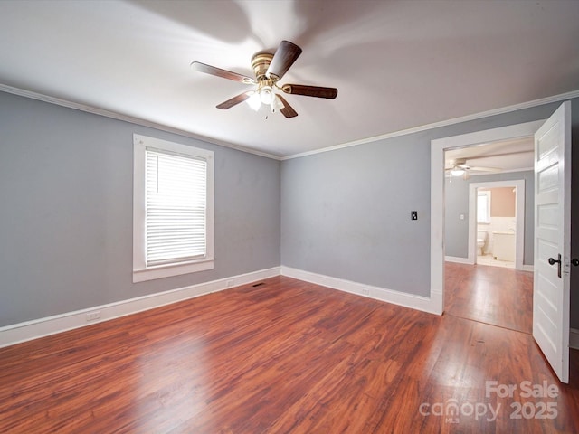 spare room featuring a wealth of natural light, wood finished floors, a ceiling fan, and ornamental molding