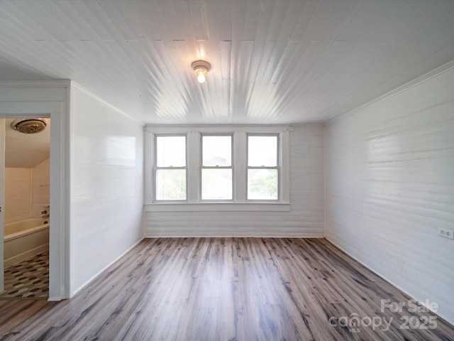 unfurnished room featuring crown molding, wooden ceiling, and wood finished floors