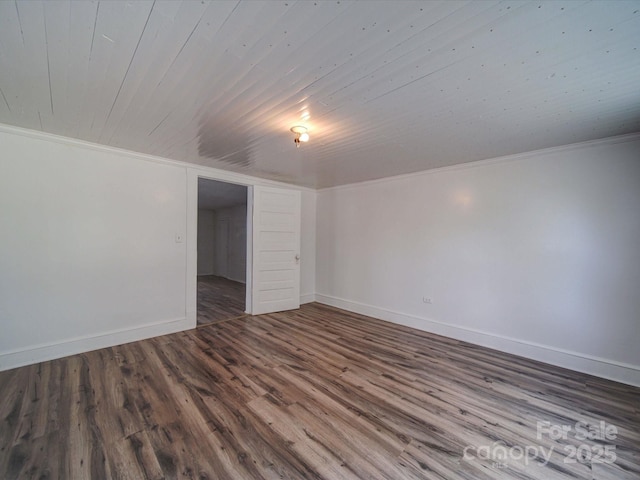spare room with baseboards, ornamental molding, wooden ceiling, and wood finished floors