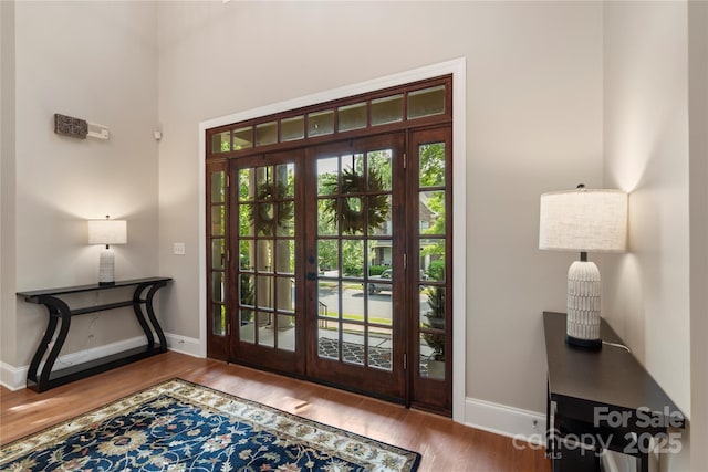 entrance foyer with baseboards, french doors, and wood finished floors