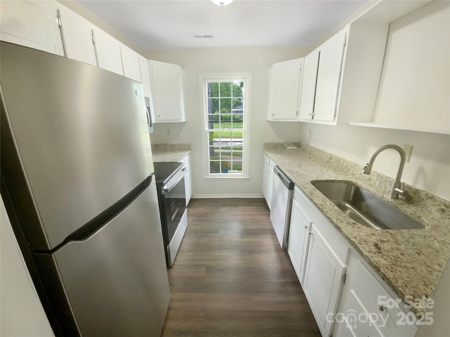 kitchen featuring appliances with stainless steel finishes, dark wood finished floors, a sink, light stone counters, and white cabinets