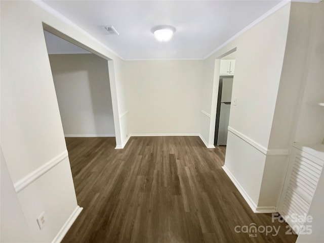 interior space featuring crown molding, baseboards, and wood finished floors