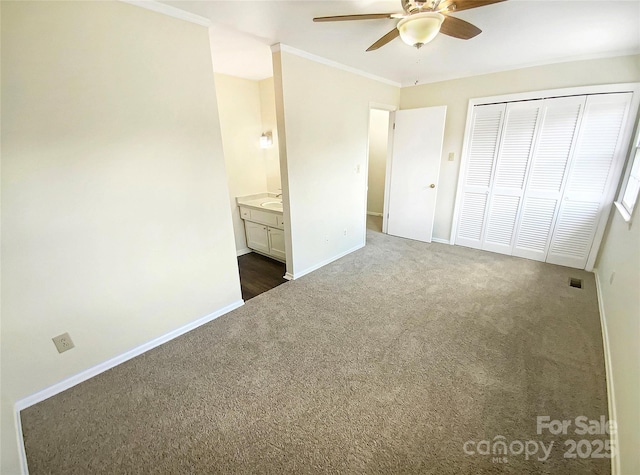 unfurnished bedroom featuring crown molding, visible vents, a closet, dark colored carpet, and baseboards