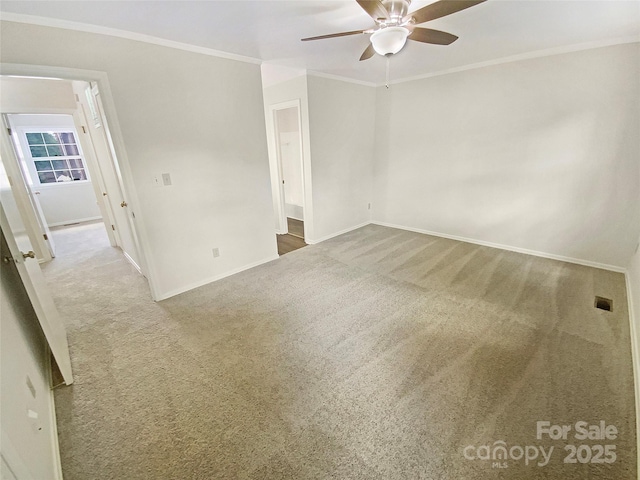 carpeted empty room featuring baseboards, a ceiling fan, and ornamental molding