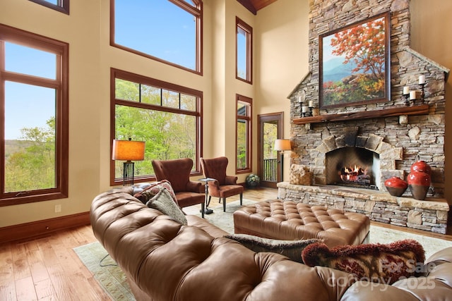 693 Thunderhill Trl, Blowing Rock, NC 28605 - living room featuring light wood-style floors, baseboards, a high ceiling, and a fireplace