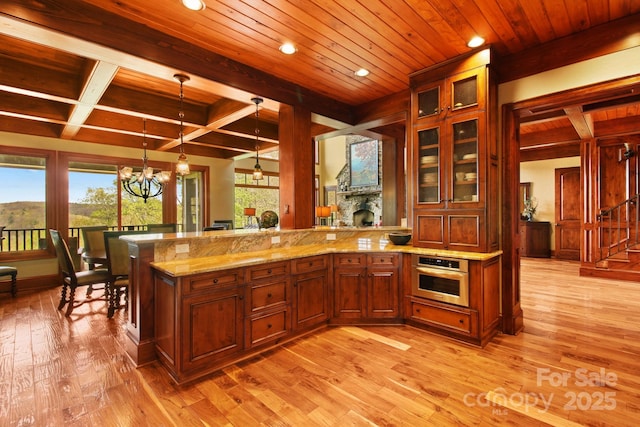 693 Thunderhill Trl, Blowing Rock, NC 28605 - kitchen featuring stainless steel oven, light wood-style flooring, a peninsula, beam ceiling, and a chandelier