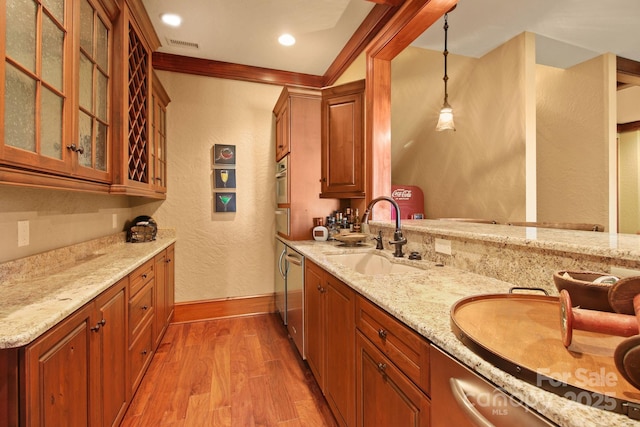 693 Thunderhill Trl, Blowing Rock, NC 28605 - kitchen featuring a sink, a textured wall, light wood finished floors, light stone counters, and brown cabinetry