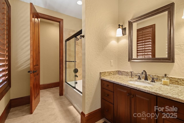 693 Thunderhill Trl, Blowing Rock, NC 28605 - bathroom featuring vanity, combined bath / shower with glass door, a textured wall, and baseboards