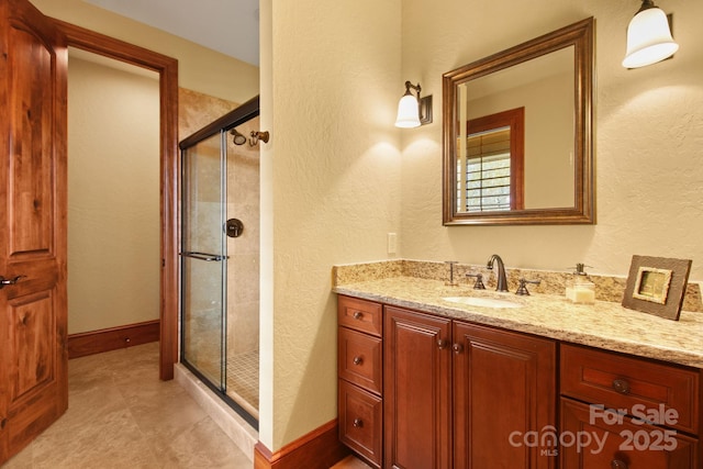 693 Thunderhill Trl, Blowing Rock, NC 28605 - full bathroom featuring a stall shower, vanity, baseboards, and a textured wall